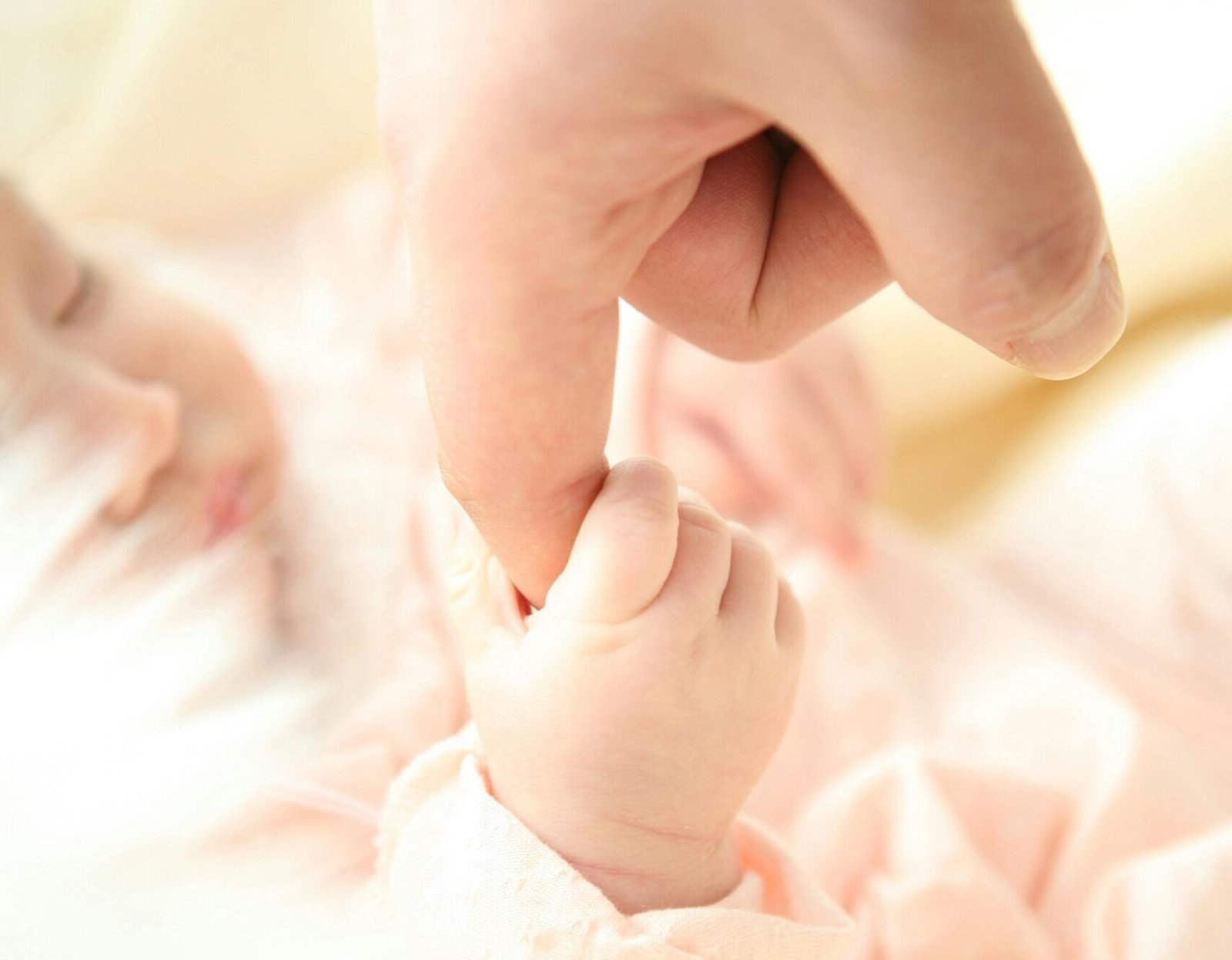 Heartwarming close-up of a baby holding a parent's finger, symbolizing love and connection.